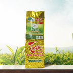 Bao bì Trà Búp Truyền Thống 100g màu vàng, chụp chính diện trên nền đồi chè.