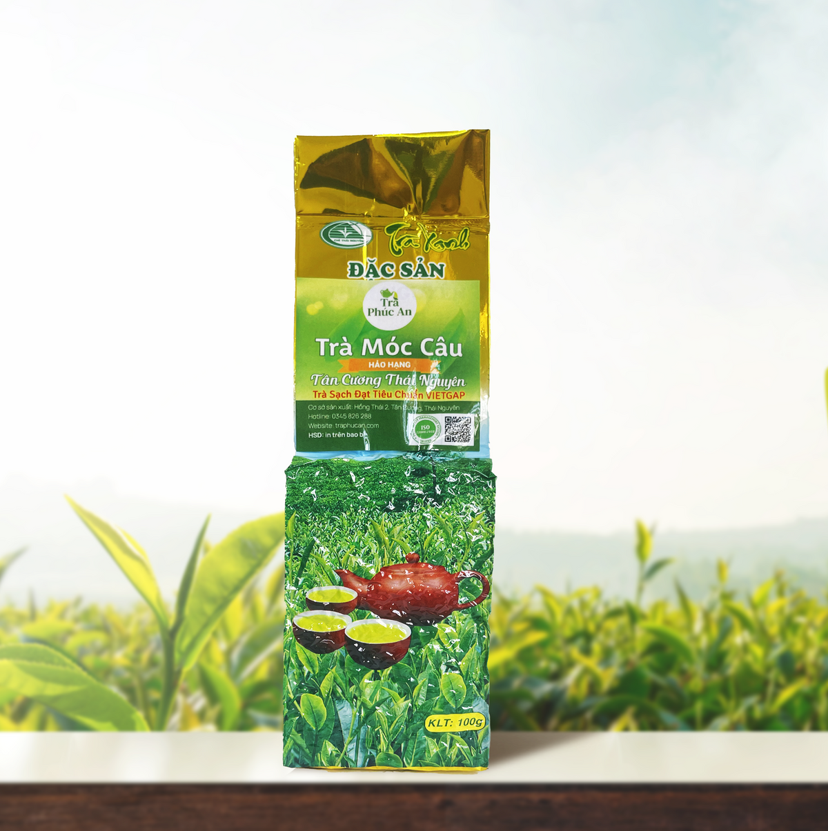 Gói Trà Móc Câu Hảo Hạng 100g màu xanh và vàng, in hình ấm đỏ cùng các chén trà.